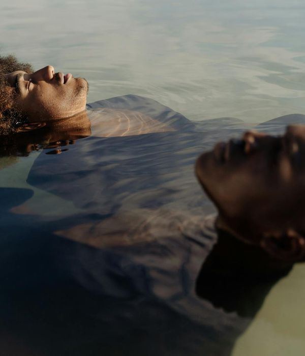 Calm person meditating outdoors with a peaceful expression.